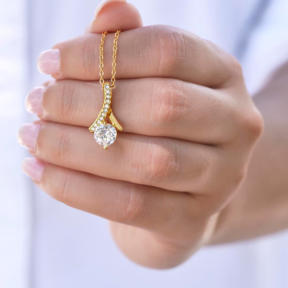 Hand holding the Sparkling Radiance Necklace pendant in yellow gold finish