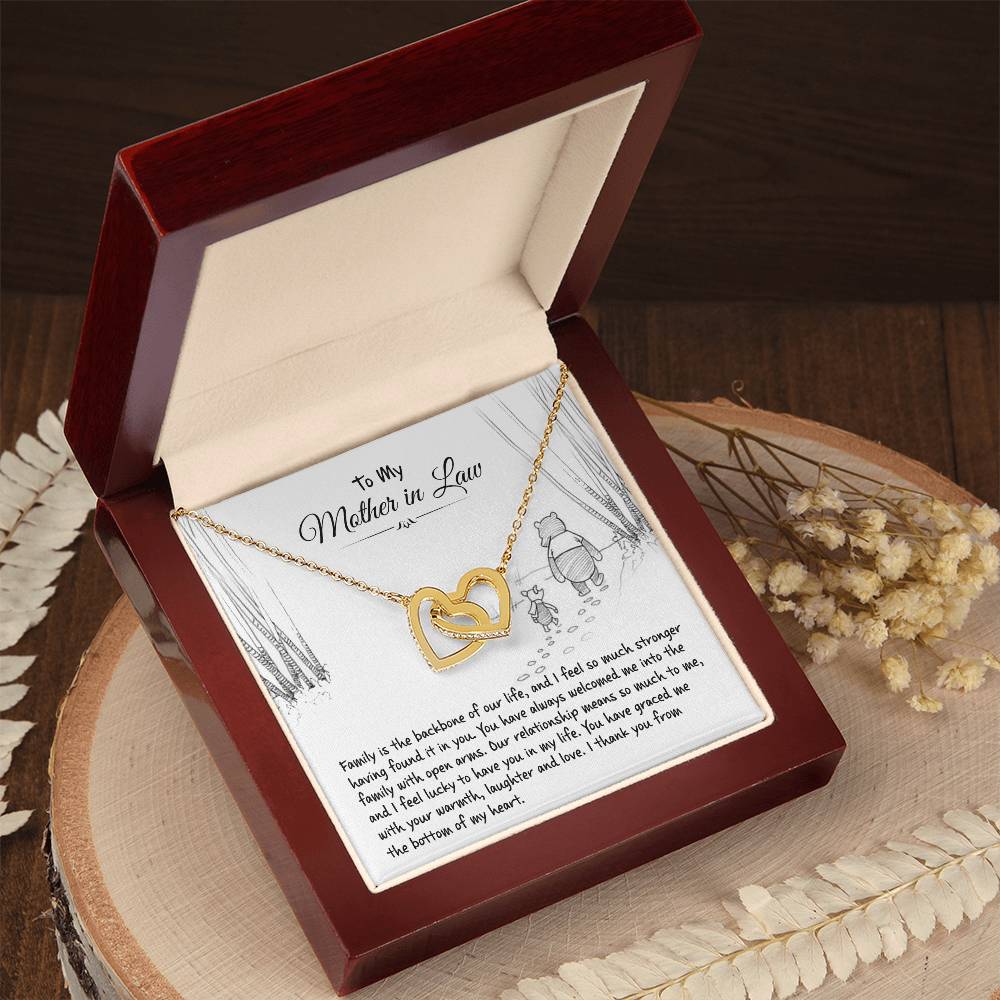 Interlocking Hearts Necklace in yellow gold with To My Mother in Law card in an open gift box on a wood slab