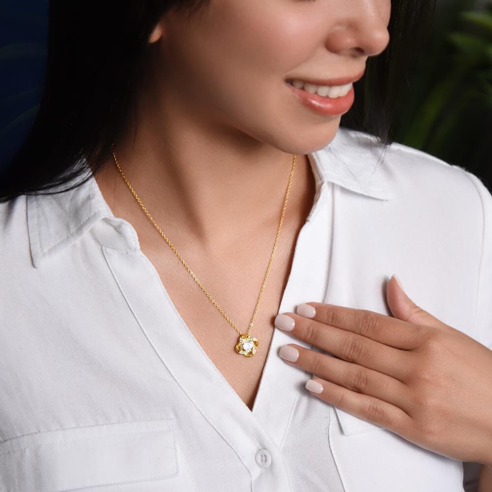Model wearing the Love Knot Necklace pendant, yellow gold finish