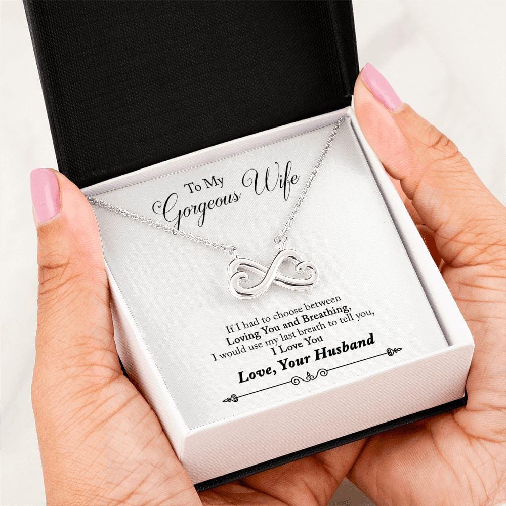 Hand holding the gift box with Infinity Necklace and To My Gorgeous Wife message card