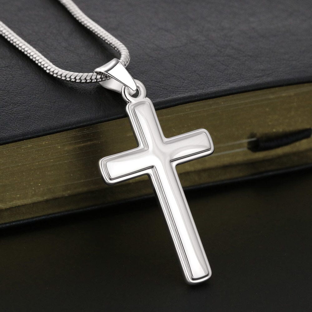 Personalized Cross Necklace pendant resting on a book